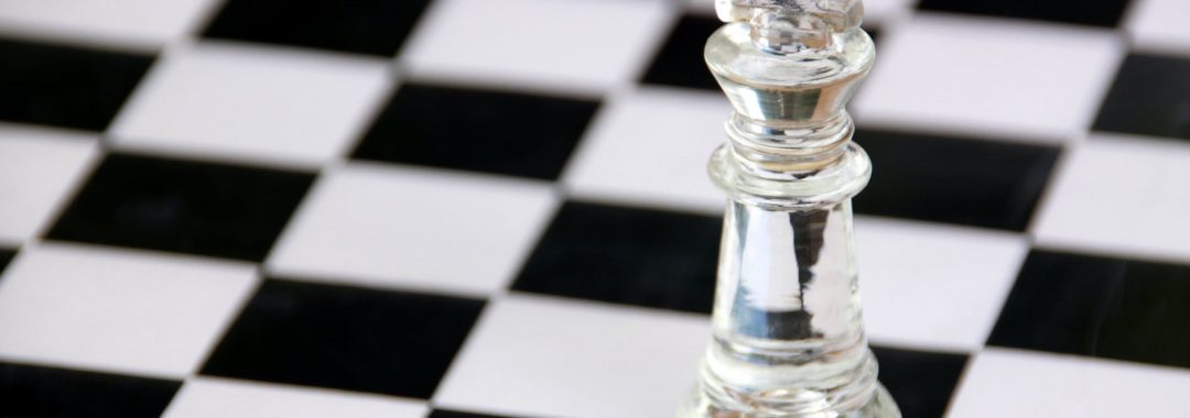 clear glass chess piece on black and white checkered table